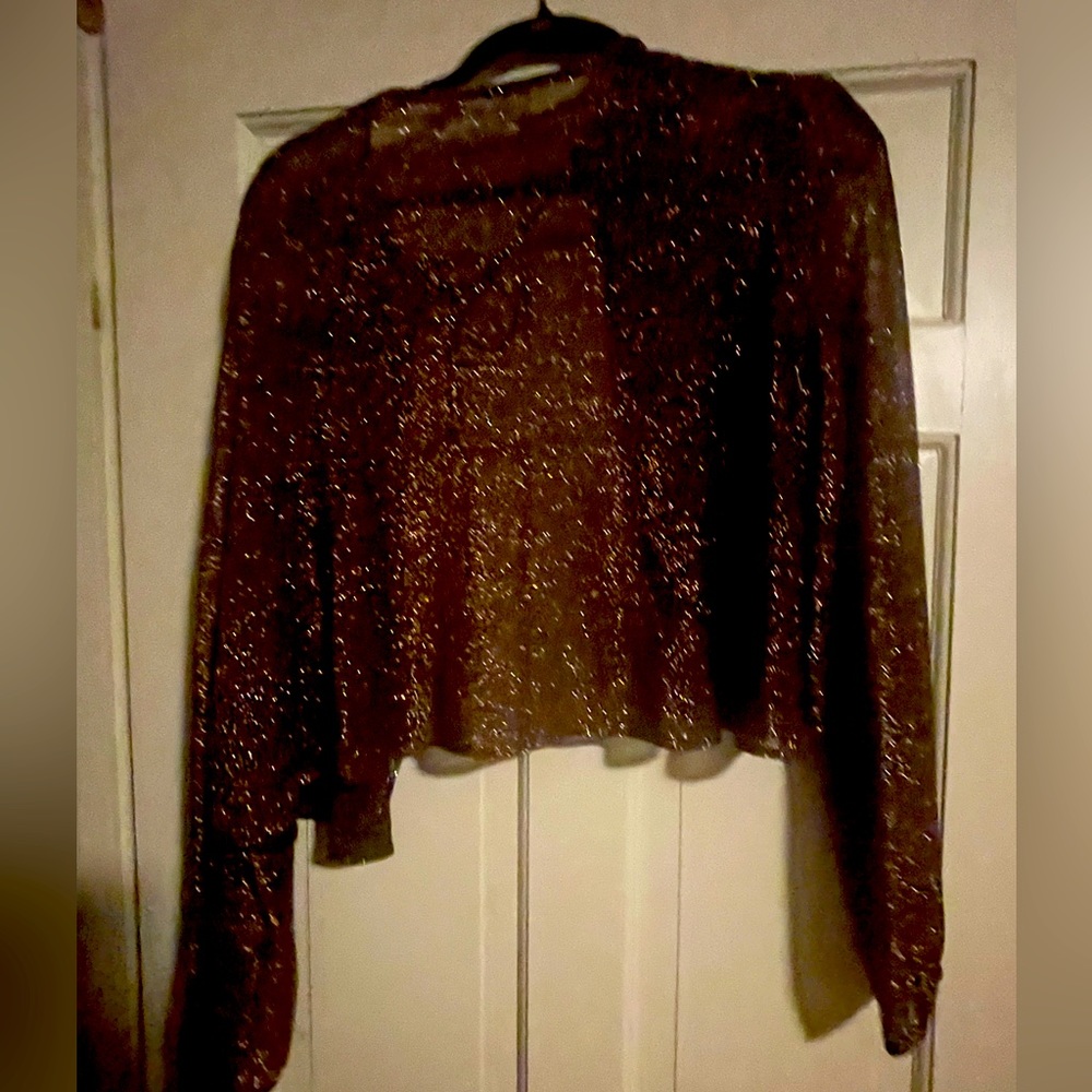 No brand enclosed .. it says dry clean only .. Beautiful sheer jacket